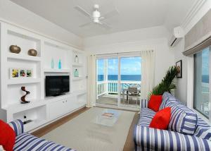 James CisternCoastal Haven: Charming Beachfront Cottage with Pool的客厅配有蓝色的沙发和电视