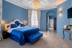 Bertsdorf阿申瑞尼兹斯加罗酒店的一间蓝色卧室,配有一张大床和吊灯