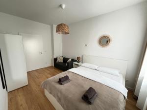 汉诺威60qm - 2 rooms - free parking - city - MalliBase Apartments的白色卧室设有一张大床和一张沙发