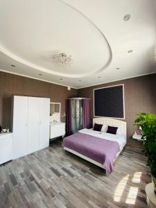 丰坦卡Готель Лаванда на Ривьере , Карпатский чан, Фонтанка 1 Одесса的一间卧室配有一张大床和紫色毯子