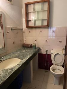 帕坦Kasaa home的一间带卫生间、水槽和镜子的浴室