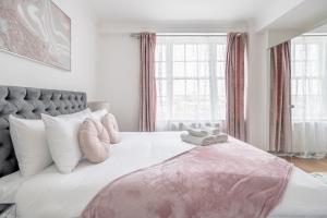 伦敦Stunning Flat Next To Hyde Park的一间卧室配有一张带粉色毯子的大床