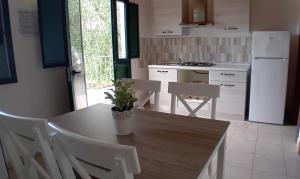 佩斯基奇Agriturismo Valle Dei Gelsi的厨房配有桌椅和冰箱。