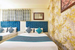 新德里Hotel Edission View At Airport的一间卧室设有两张床和蓝色床头板