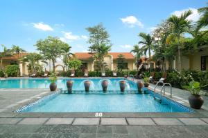 宁平Dong Ne Tam Coc Hotel & Resort的棕榈树度假村的游泳池