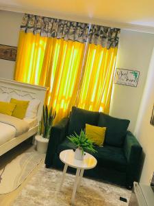 思由基茅Indesign Makumbi park studio Apartment D4-5,Syokimau的客厅配有绿色沙发和黄色窗帘
