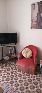莱齐尼昂科尔比埃Le Nid de Jeanne的客厅里配有红色椅子和枕头