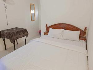 KotabumiOYO 93902 Guest House Pahlawan Syariah的卧室配有白色的床和桌子