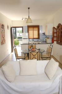 帕福斯Sunset Green 01的一间带白色沙发的客厅和一间厨房
