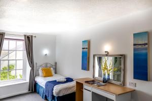 切普斯托博福特酒店的一间卧室配有一张床和一张带镜子的书桌