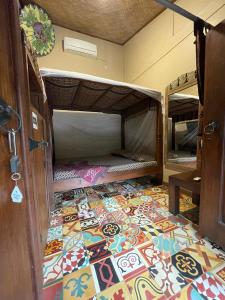 日惹Bedhot Homestay的客房铺有色彩缤纷的瓷砖地板,配有双层床。