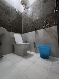勒克瑙Hotel JP Inn的一间带卫生间、淋浴和蓝色桶的浴室