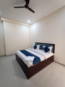 勒克瑙Hotel JP Inn的一间卧室配有一张带蓝色和白色枕头的床