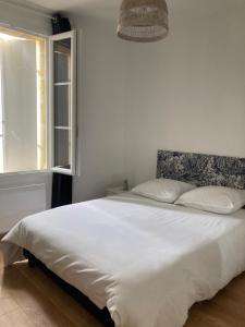 Saint-Genès-de-CastillonL'Appartement du Comptoir的卧室配有一张大白色床和窗户