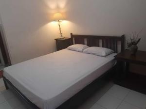 斯勒曼Capital O 93938 Wisma Pamungkas Syariah的卧室配有一张带灯的白色大床