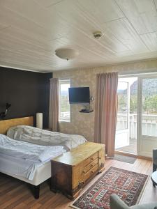 UlvsvågUlvsvåg Gjestgiveri og Fjordcamping AS的一间卧室配有两张床和一台平面电视