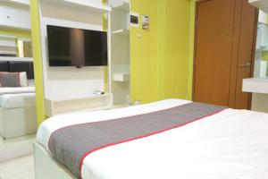 当格浪Super OYO Capital O 93910 Asia Rooms at Green Lake View Ciputat的一间卧室配有一张床和一台平面电视