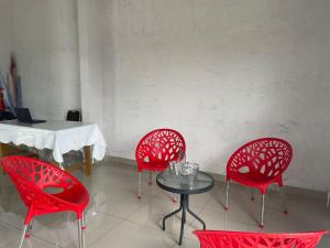 棉兰OYO 93947 Bahagia Guest House的两个红色的椅子和一张桌子