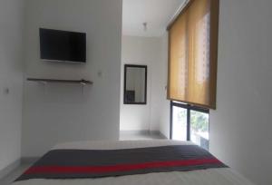 雅加达OYO 93958 J&B Smart Jatinegara的一间卧室设有一张带平面电视的床。