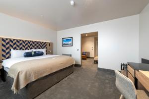 格拉斯哥Sandman Signature Glasgow Hotel的一间卧室配有一张大床和一张书桌