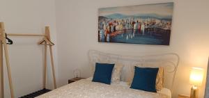 默克斯卡Apartment Marlena的一间卧室配有一张带蓝色枕头的床和一幅画