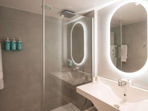波尔多诺沃特波尔多拉克酒店的浴室配有盥洗盆和带镜子的淋浴