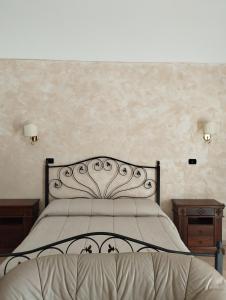 圣乔瓦尼·罗通多Tenuta Santa Lucia的一间卧室配有一张带2个床头柜和2张桌子的床