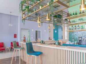 卡萨布兰卡宜必思卡萨布兰卡市中心酒店的餐厅设有酒吧,配有蓝色和绿色的椅子
