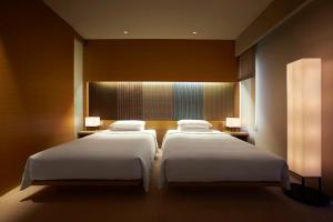 京都京都凯悦酒店的配有2盏灯的酒店客房的2张床