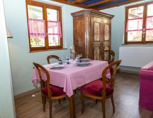 凯泽贝尔Origin'alsace的用餐室配有带粉红色桌布的桌子