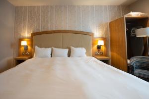 亨廷登桑福德豪斯威瑟斯本酒店的一张大白色的床,位于酒店客房内