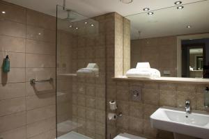 亨廷登桑福德豪斯威瑟斯本酒店的一间带玻璃淋浴和水槽的浴室