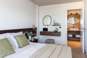 赫索尼索斯信天翁Spa度假酒店的一间卧室配有一张带水槽和镜子的床