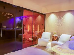 蒂米什瓦拉ibis Timisoara City Center的一间设有两把白色椅子和滑动玻璃门的房间