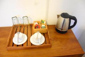 康提Cozy Homestay Kandy的一个带两个白板的木制托盘和咖啡壶