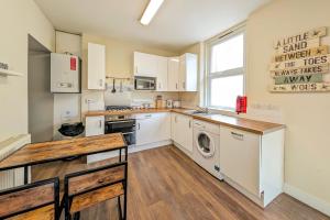 伯恩茅斯Town Centre House for 6 Guests的厨房配有白色橱柜、洗衣机和烘干机