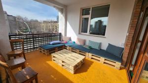 乌兰巴托Ulaanbaatar Hostel的阳台设有长凳、桌子和窗户。