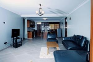 坎帕拉Munyonyo Heights Apartments的带沙发和电视的客厅