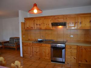 卡瓦莱塞Amazing Apartment in Cavalese with Shared Terrace的厨房配有木制橱柜和炉灶烤箱。