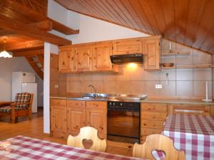 卡瓦莱塞Amazing Apartment in Cavalese with Shared Terrace的厨房配有木制橱柜、水槽和桌子