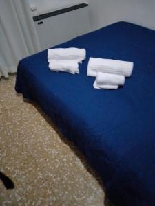 塞维索伦巴第大区酒店的蓝色的床,上面有毛巾