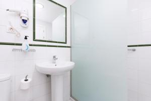 科拉雷侯Apartamentos Erika - Adults Only的白色的浴室设有水槽和镜子
