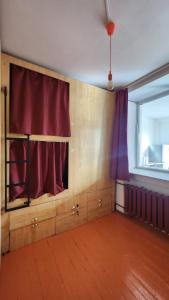 乌兰巴托Ulaanbaatar Hostel的一间空房间,有红色的窗帘和窗户