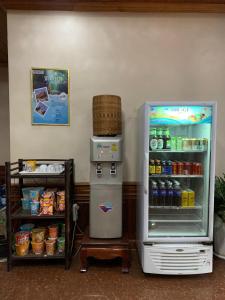 琅勃拉邦Heuang Paseuth Hotel 香帕赛酒店的冰箱冰柜,位于货架旁,提供饮料