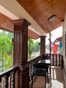 琅勃拉邦Heuang Paseuth Hotel 香帕赛酒店的木制门廊配有桌椅