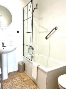 罗萨斯Puig Rom的白色的浴室设有浴缸和水槽。