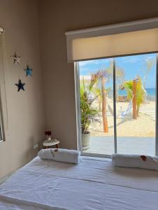 CanoasRibera Del Norte的一间卧室配有一张床,享有海滩美景