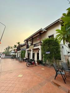 琅勃拉邦Heuang Paseuth Hotel 香帕赛酒店的停在前面的一座带摩托车的建筑