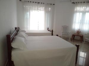 卡卢特勒Ananthaya -the infinity的一间卧室设有两张白色的床和窗户