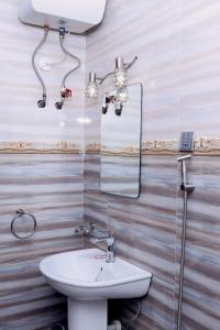 坎帕拉Munyonyo Heights Apartments的一间带水槽和镜子的浴室